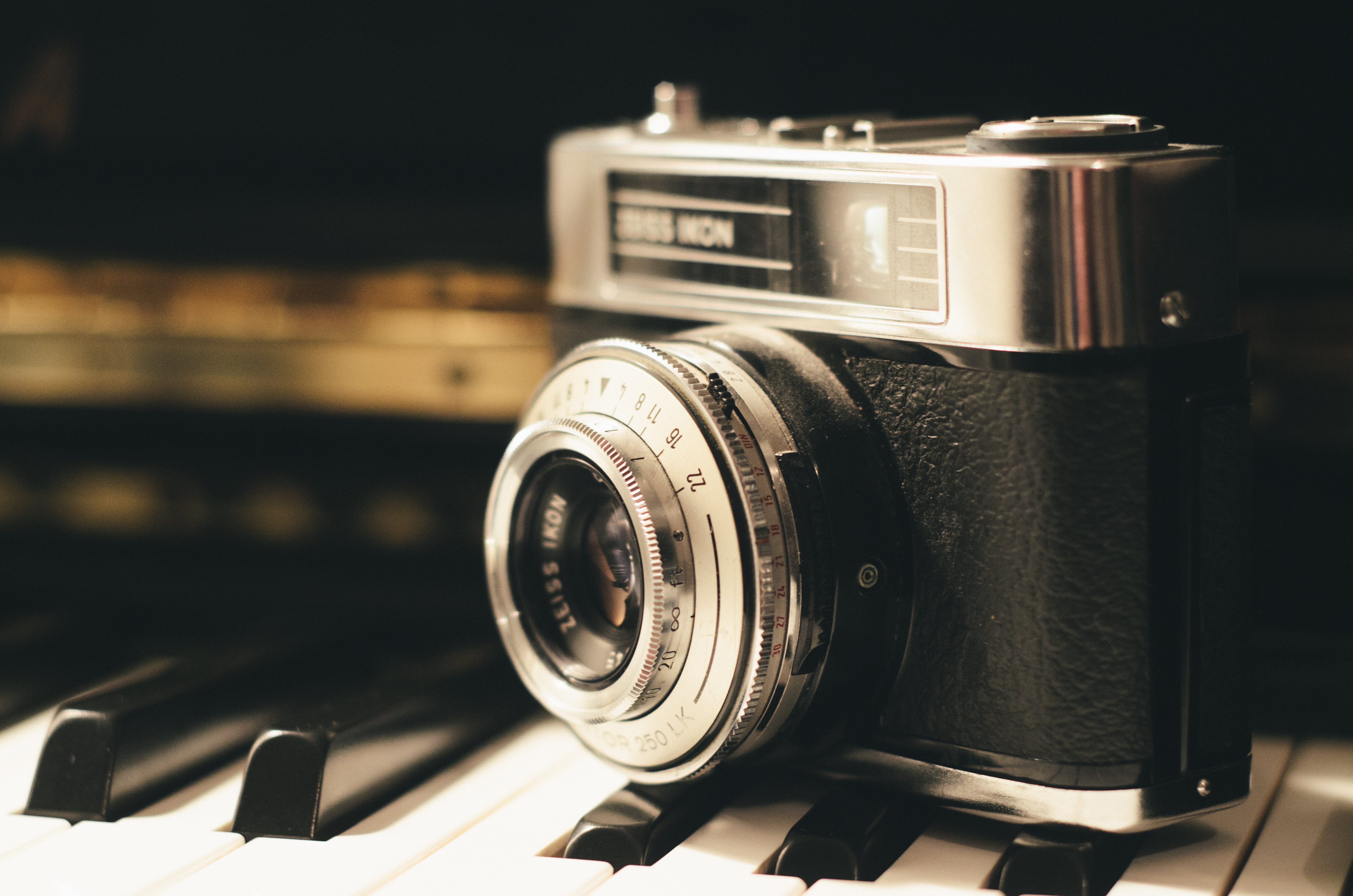 Vintage camera positioned on piano keys